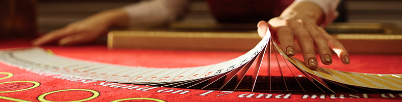 Hands shuffling cards over a table.
